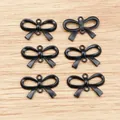 Detailed view of six matte black bow-shaped alloy pendants for DIY jewelry making - Black