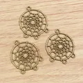 Three bronze alloy dreamcatcher charms for DIY jewelry making on wood background - Bronze