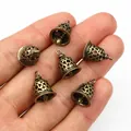 Detailed macro of six 3D antique bronze hollow bells for DIY jewelry making - Bronze