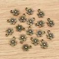 Colgantes de flores en aleación de bronce antiguo para bisutería en fondo de madera - Bronce antiguo