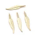 Polished gold feather charms for DIY jewelry making, showcasing intricate leaf-like texture - KC Gold