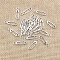 Silver safety pin charms made of alloy for DIY jewelry making on burlap background - 16x5mm