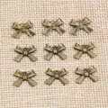 Neuf pendentifs nœuds vintage en alliage de bronze disposés sur un fond en lin rustique - Bronze