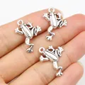 Three vintage silver frog pendants for DIY jewelry making shown in hand for scale - Antique Silver