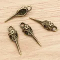 Bronze bird skull charms for jewelry making, 41x13mm vintage alloy pendants on wood surface - Bronze
