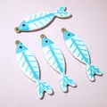 Macro view of four fish bone pendants with blue enamel finish and gold stainless steel frame - Blue and White Fish Bone Style (AJ5-15)