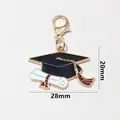 Detail of graduation cap and diploma charm with lobster clasp measuring 28mm by 20mm - Cap White Scroll (SG-O7-39-AB1-02)