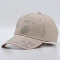 Detail of beige cotton baseball cap featuring colorful rhinestone butterfly and floral patterns - Floral Pattern / Khaki