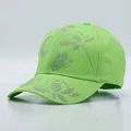 Close-up of sparkling rhinestone dragonfly and flower patterns on neon green cotton cap - Floral Pattern / Grass Green