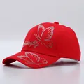 Close-up of red cotton baseball cap with rhinestone butterfly pattern and embroidery - Butterfly Pattern / Red