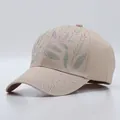Detailed macro of beige cotton baseball cap featuring colorful rhinestone leaf patterns - Bamboo Leaf Pattern / Khaki