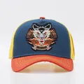 Dettaglio del ricamo a forma di lupo su cappellino trucker blu e giallo con rete - Regolabile / Leone Tesa Blu Notte Arancione