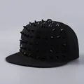 Close-up of black snapback hat with metallic cone studs in a punk streetwear style - Black Rivets