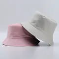 Close-up of pink and beige cotton bucket hats showing precision stitching on the brim - One Size / Light Pink And Beige