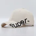 Detail der 3D-Stickerei 'super.' auf der cremefarbenen Baumwoll-Baseballkappe mit 60-Logo - Verstellbar / Beige mit Super-60-Stickerei