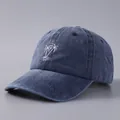 Dettaglio del ricamo a palma bianca su cappellino in cotone blu navy lavato - Regolabile / Blu Denim