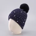 Detail of dark blue winter knit beanie featuring faux fur pom and faux pearl accents - One Size / Dark Blue