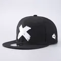 Detail of black snapback hat featuring white X embroidery and silver sport cap sticker - Adjustable / Hat Only / White