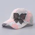 Close-up of pink lace baseball cap with sparkling rhinestone butterfly and mesh detail - Adjustable / Pink