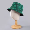 Detailed close-up of a double-sided green bucket hat with clover print on a mannequin head - One Size / Green Clover