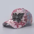 Detailed view of lace floral embroidery and sparkling rhinestone butterfly on baseball cap - Adjustable / Rose Red