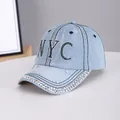 Light blue denim baseball cap featuring NYC rhinestone lettering and studded brim accents - NYC Light Blue