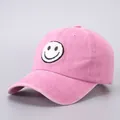 Close-up of pink vintage washed cotton baseball cap with embroidered smiley face patch - Adjustable (Adult) / Pink Smiley Face