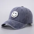 Close-up of a blue denim baseball cap featuring a white fuzzy smiley face patch and texture - Adjustable (Adult) / Navy Smiling Face