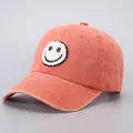 Detail of vintage orange washed cotton baseball cap with embroidered smiley face patch - Orange Smiley Face