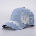 Distressed light blue denim baseball cap with vintage frayed holes and tie-dye splatter effect - Adjustable / Light Blue Distressed Denim