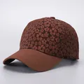 Macro detail of brown baseball cap with floral jacquard texture and stitched brim - Brown Floral