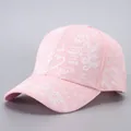 Close-up of pink baseball cap featuring white graffiti print and detailed cotton stitching - Pink-B52