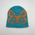 Dettaglio del berretto jacquard morbido con motivo a farfalla arancione su blu intenso - Taglia unica / Azzurro - Farfalla