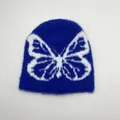 Dettaglio del berretto in peluche blu con motivo jacquard a farfalla bianca e trama morbida - Taglia unica / Farfalla Blu Reale