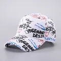 Detailed view of white canvas baseball cap with black and red graffiti letters and patterns - White-STER