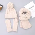 Flat lay of cream knit winter set featuring bobble hat, scarf and touchscreen gloves - Beige