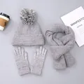 Close-up of winter knit set including touchscreen gloves, scarf, and pompom beanie - Hat with Pom-poms / Gray