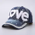 Detailed macro view of denim baseball cap with LOVE rhinestone and pearl embellishments - Pearl Rhinestone LOVE Style / Deep Blue Pearl Rhinestone LOVE