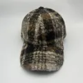 Detailopname van de winterse baseballpet met luipaardprint en zachte fleece textuur - Koffie Ruit