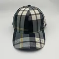 Close-up of the multi-color plaid pattern and stitching on a classic cotton baseball cap - Adjustable / Green and White Houndstooth
