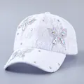 Detail of white lace baseball cap featuring shimmering rhinestone butterfly decorations - Butterfly Design / White