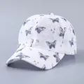 Detail der weißen Spitzen-Baseballkappe mit lila Schmetterlingsmustern und Stickerei - Verstellbar / Einfache Spitze Schwarzer Schmetterling