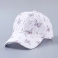 Detailaufnahme einer weißen Spitzen-Baseballkappe mit Schmetterlingsprint und Strass - Verstellbar / Einfache Spitze Rosa Schmetterling