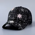 Detail einer schwarzen Spitzen-Baseballkappe mit 3D-Blumen und glänzenden Strasssteinen - Blumen-Stil / Schwarz