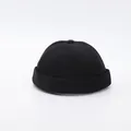 Close-up of black six-panel docker hat with structured brim and top decorative button - Adjustable / Black