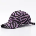 Detalle de gorra de béisbol morada con estampado de cebra, visera curva y correa - Ajustable / Púrpura Cebra