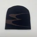 Close-up of black knitted beanie featuring brown abstract wavy patterns and soft textures - One Size / Black Coffee Jacquard