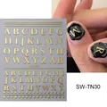 Dettaglio macro di adesivi per unghie con lettere dorate in rilievo 3D su manicure nera - SW-TN030 Oro