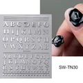 Macro detail of silver 3D alphabet nail stickers with metallic relief on black base - English Letters (SW-TN030) / SW-TN030 (Single Sheet) / Silver