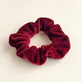 Close-up of deep red velvet scrunchie showing soft pleated texture and glossy finish - Burgundy